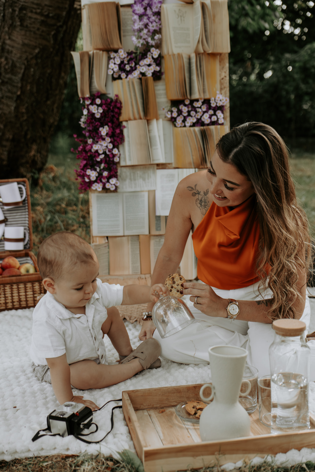 Moment de complicité mère-enfant devant un décor de livres et de fleurs